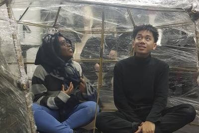 Two Access to HE students sitting inside a sculpture