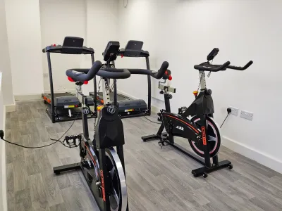a room with two exercise bikes and two running machines. 