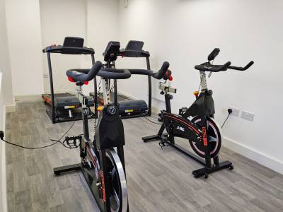 a room with two exercise bikes and two running machines.