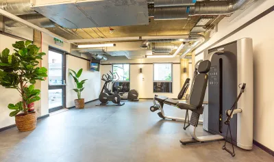 Large room with gym equipment, including exercise bikes and weight machines.