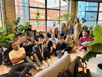 Group of people sat on floor posing 