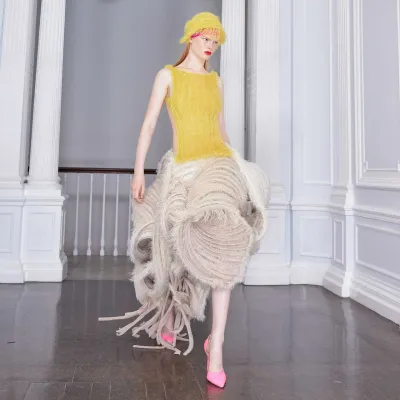 A model wearing a textured knitted dress in yellow and white