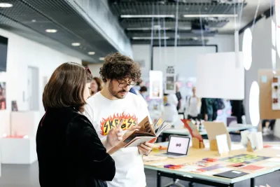 Two people discussing student work at the annual student showcase
