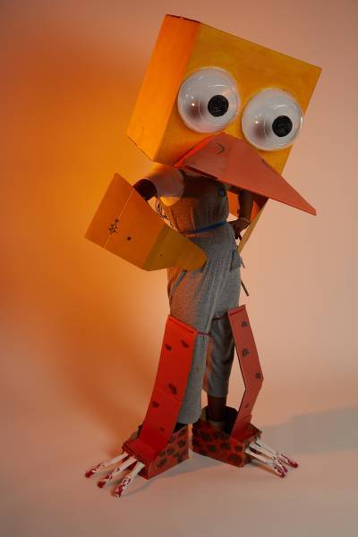 Large robotic duck made of cardboard posing with hands on hips
